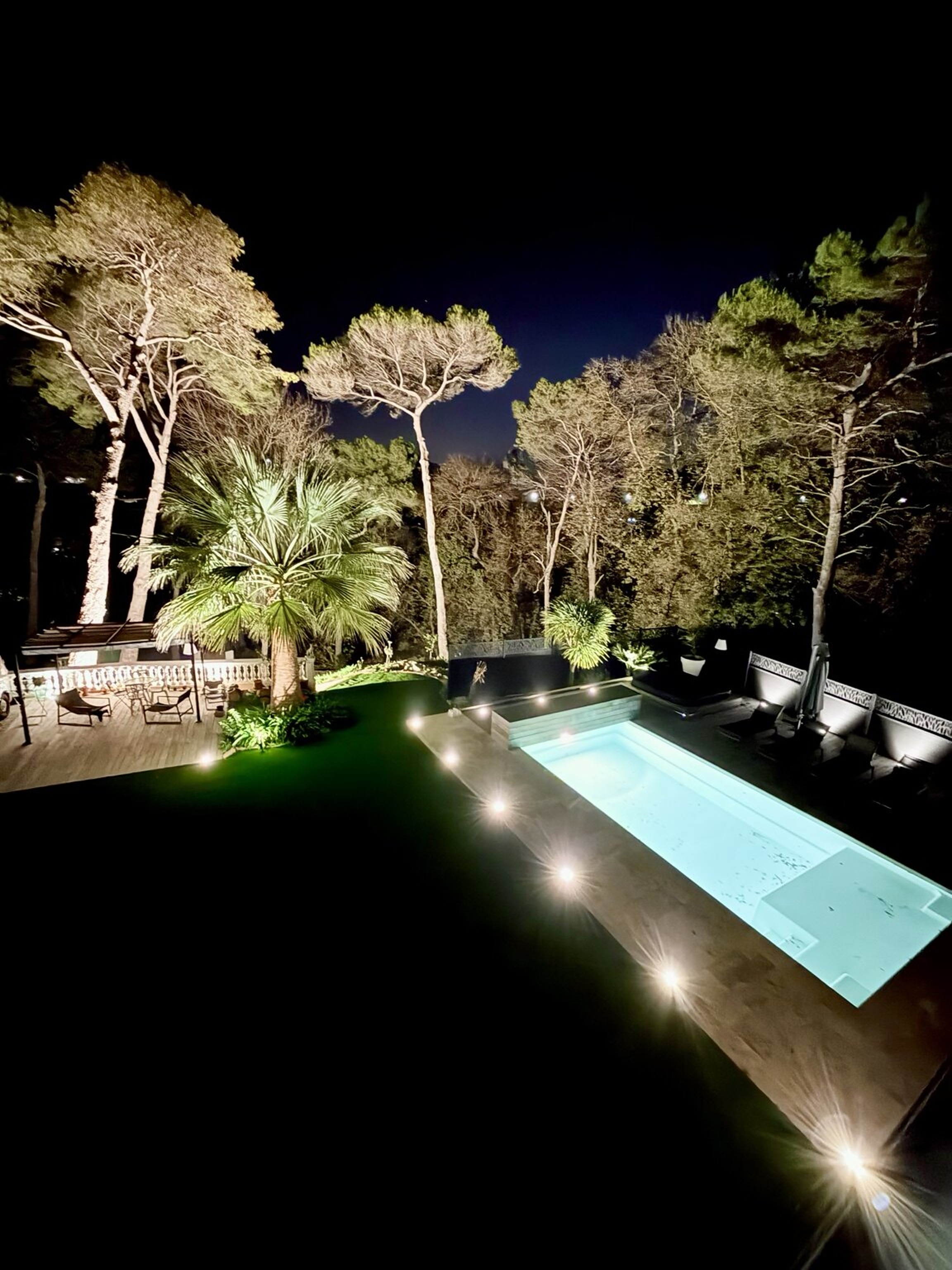 Éclairage architectural d’une piscine et d’un jardin réalisé par Mougins Électricité sur la Côte d’Azur